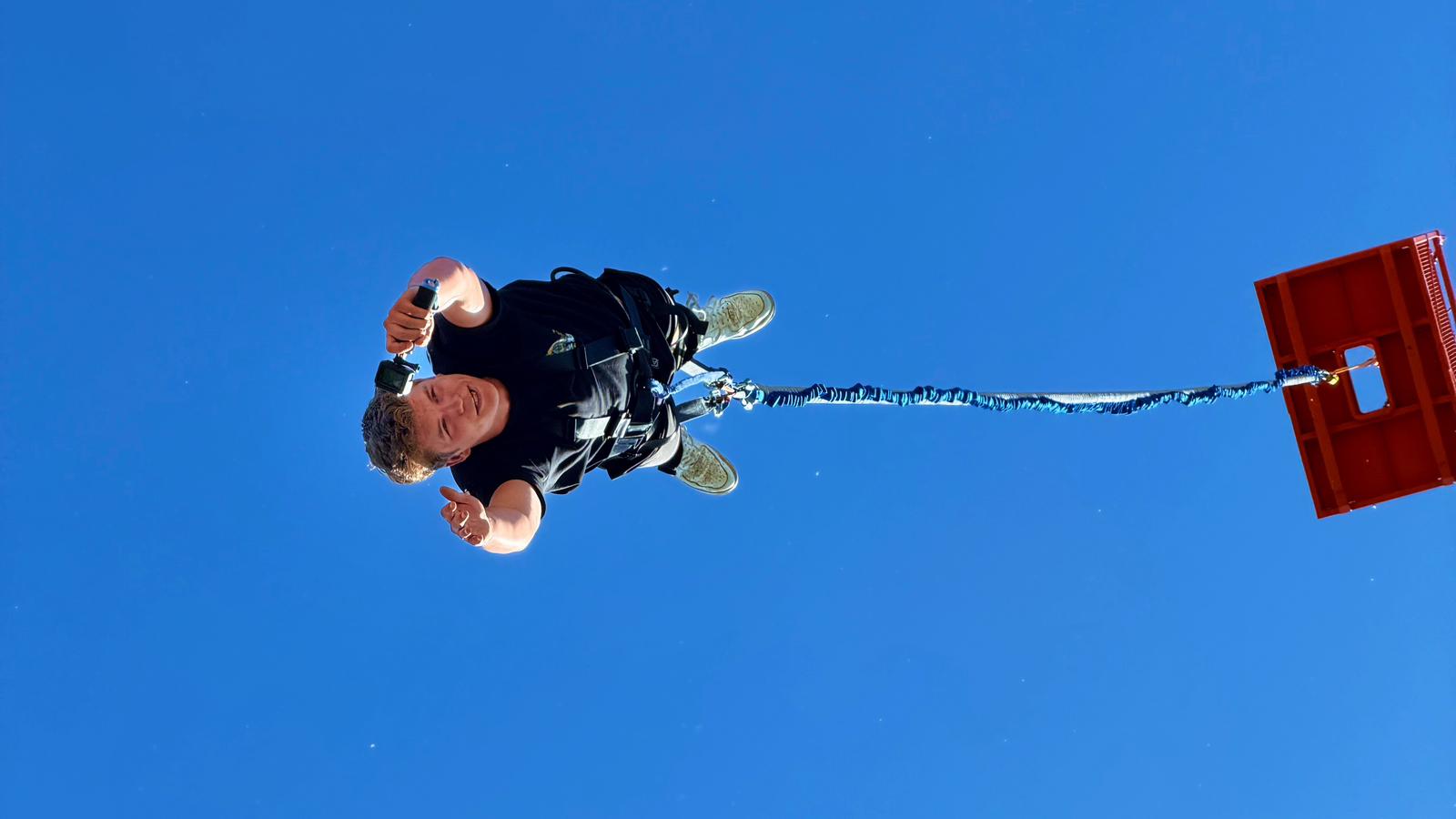 Uczestnik skoku bungee widziany od dołu na tle nieba