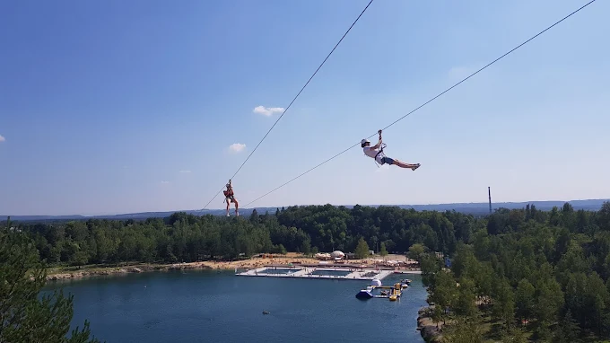 Dwie osoby zjeżdżające tyrolką nad Zalewem Balaton